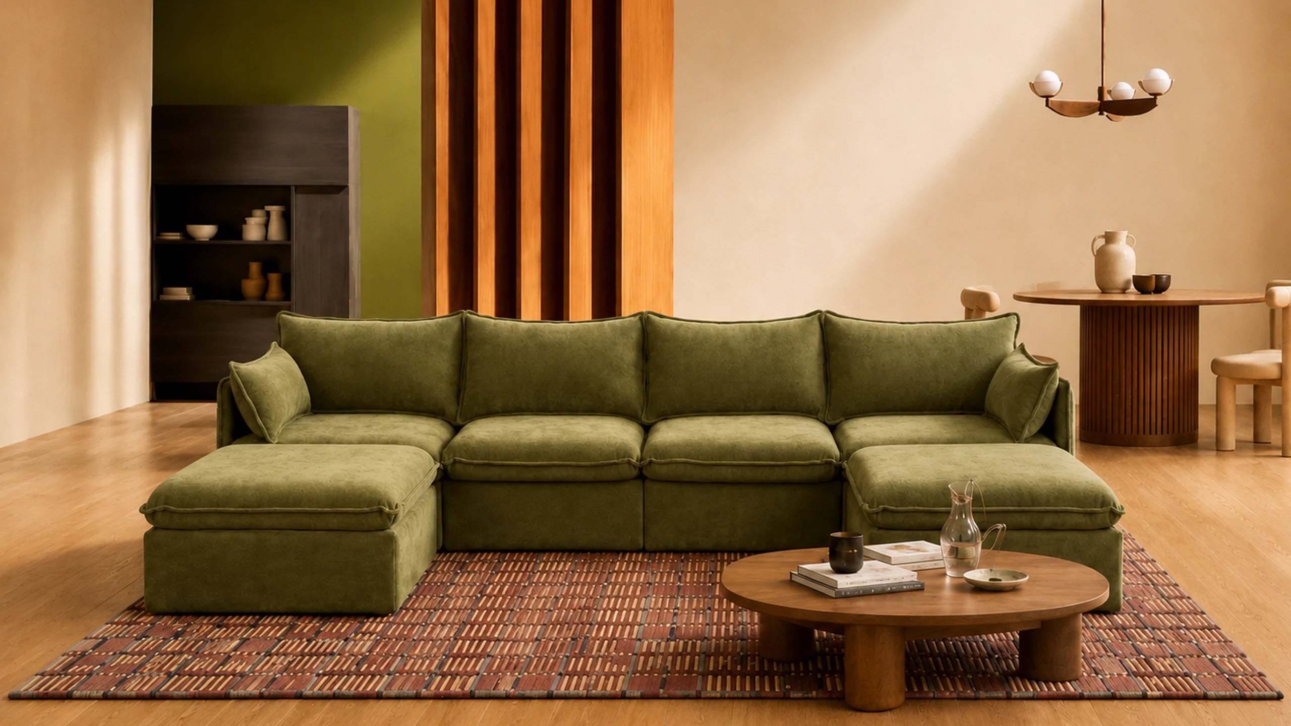 An moss green modular sectional sofa with a chaise lounge, styled in a modern living room setting with a patterned rug, wooden coffee table, and warm-toned wooden wall paneling.